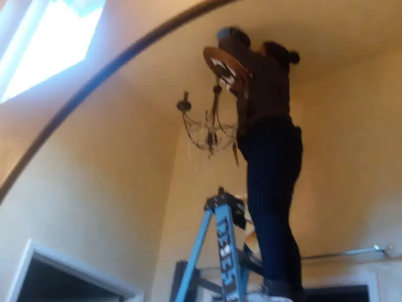 Electrician installing a chandelier in a Steilacoom residence